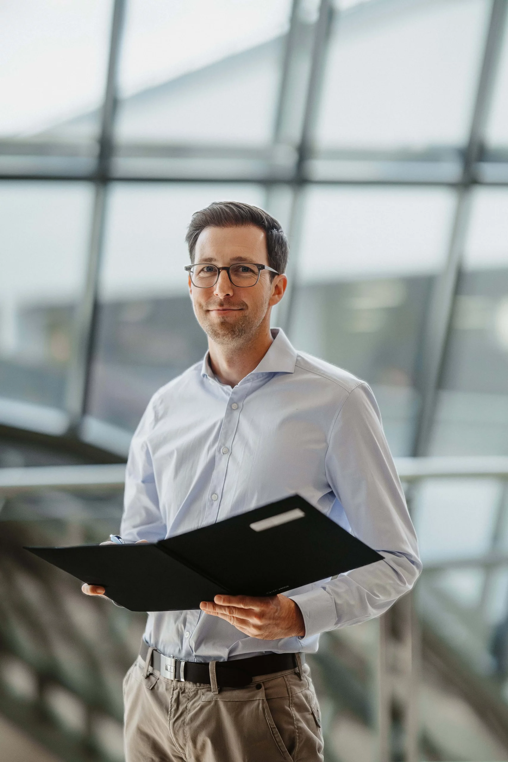 Immobilienmakler in modernem Büro mit Unterlagen – professionelle Beratung und Service rund um Immobilien im Siegerland